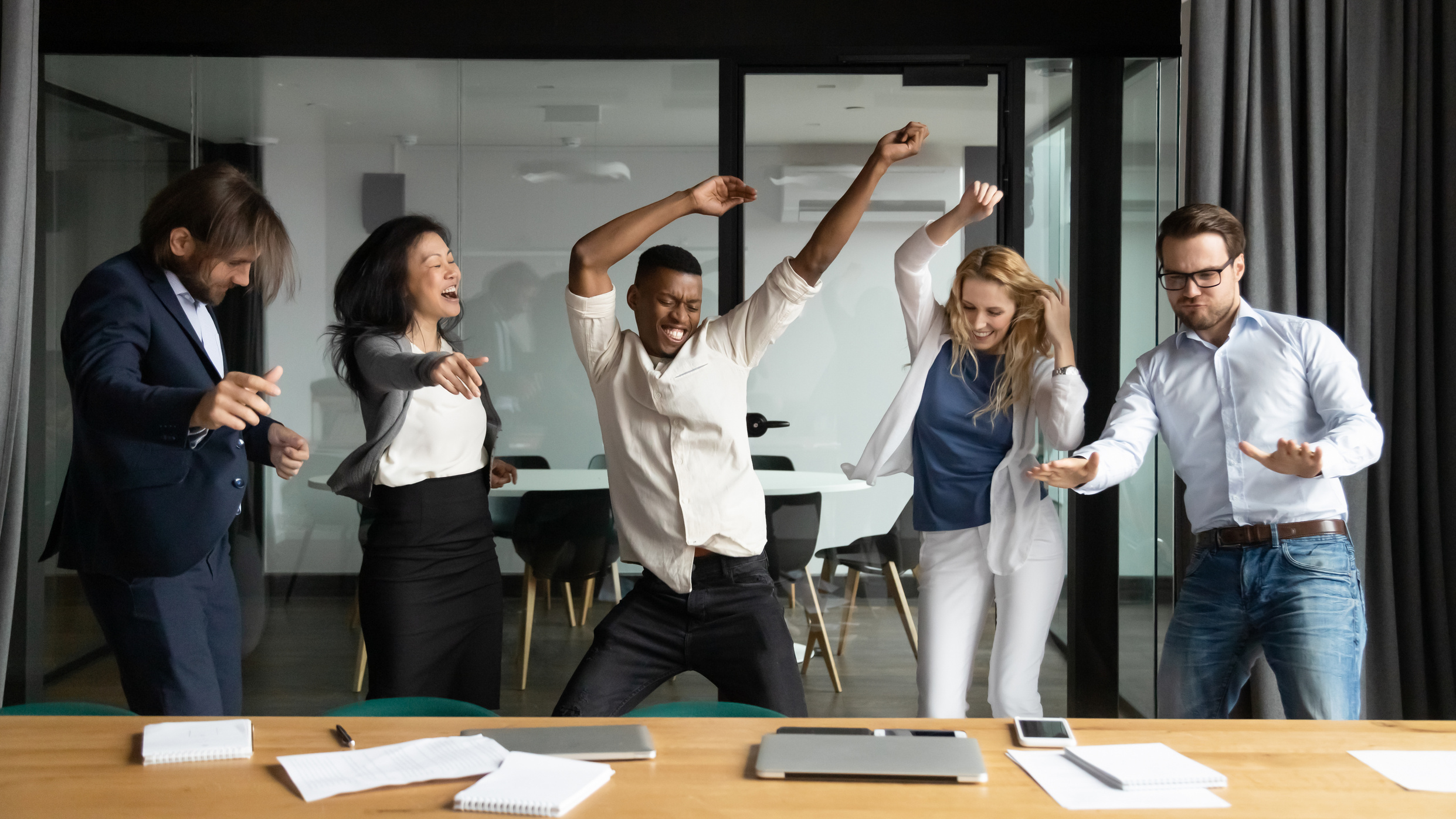 Crazy emotional multiracial business people having fun in office.